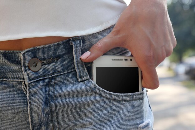 Photo white smart mobile phone in jeans pocket