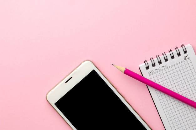 White smartphone and a notepad