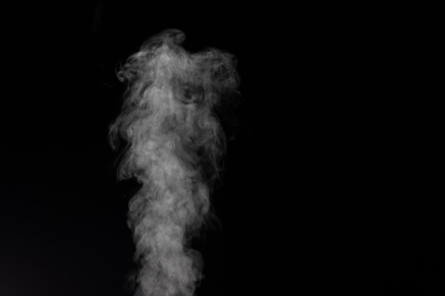 Photo white smoke on black background. figured smoke on a dark background.