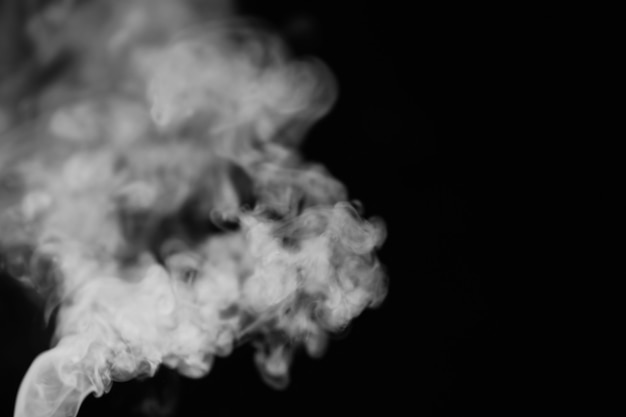 Photo white smoke on a black background. texture of smoke. clubs of white smoke on a dark background for overlay