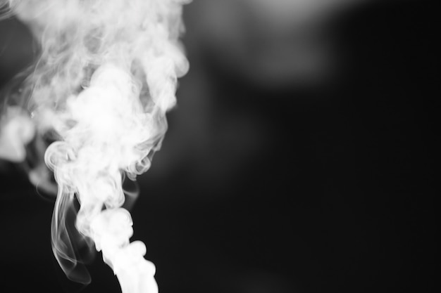 Photo white smoke on a black background. texture of smoke. clubs of white smoke on a dark background for overlay