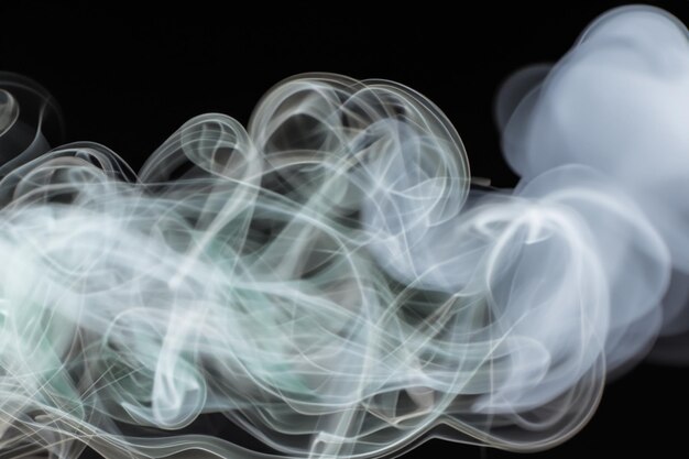 Photo white smoke fragments on black background