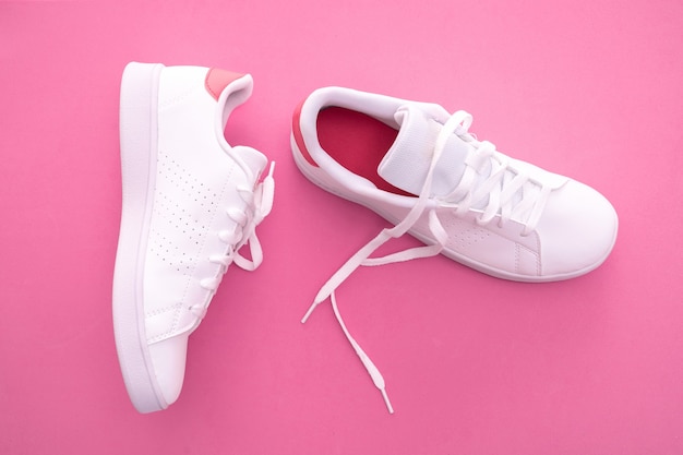 White sneakers on color background