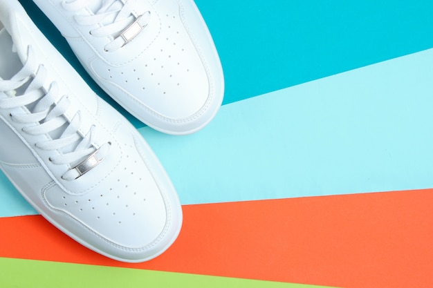 White sneakers on a colored paper table. 