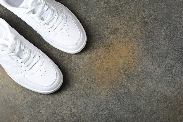 Photo white sneakers on a gray background - background with space for text