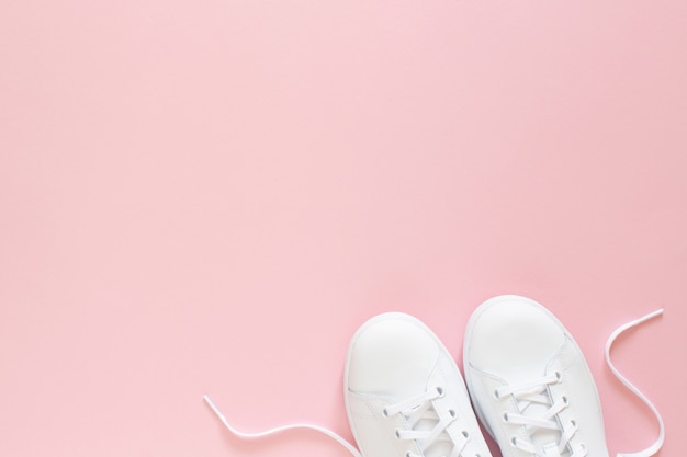 White sneakers isolated on pink