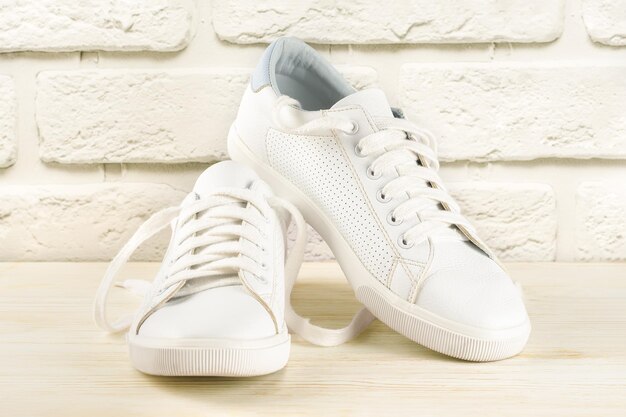 White sneakers on white brick background