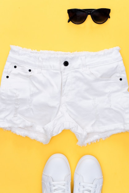 White sneakers and white shorts on yellow.