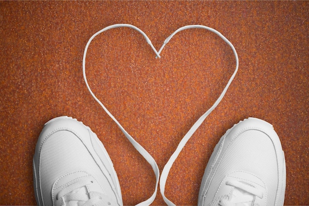 Sneakers bianche con cuore sullo sfondo. concetto di amore.