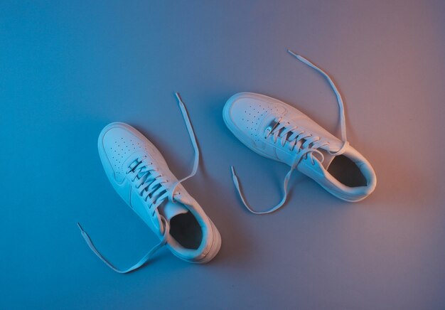 White sneakers with neon light. Top view. Minimalism