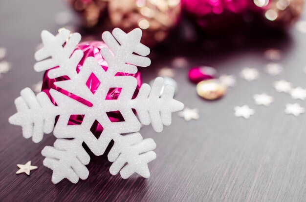 White snowflake on of magenta and gold xmas baubles.