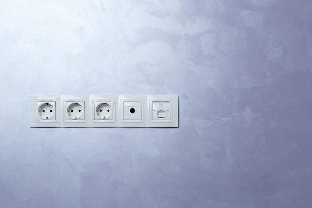 The white sockets on a wall indoor