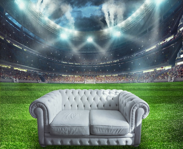 Белый диван в центре футбольного поля