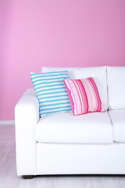 White sofa closeup in room on pink background