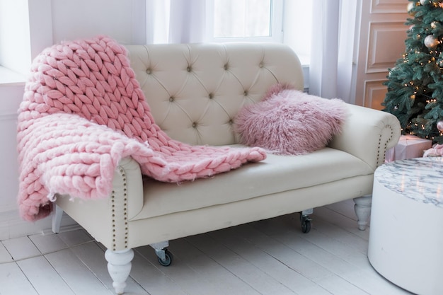 White sofa with pink plaid in the room