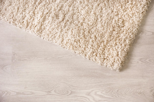 White soft carpet on wooden floor closeup