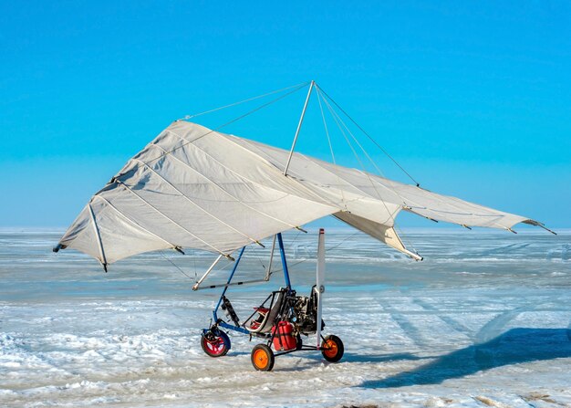 White sport hang glider on an ice field