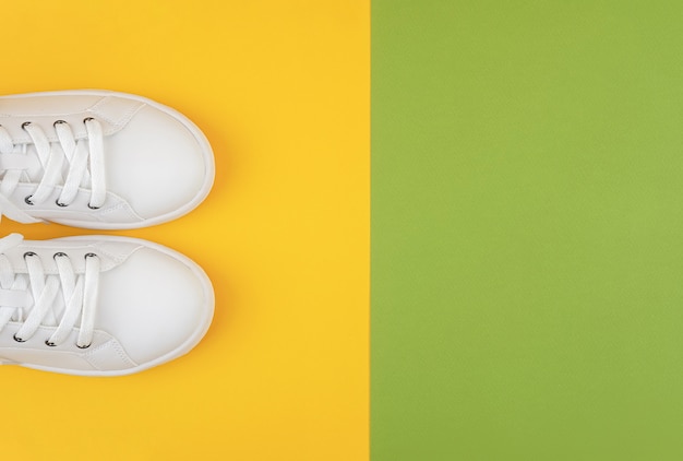 White sports shoes, sneakers with shoelaces on a green and yellow