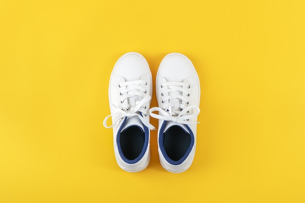 흰색 스포츠 신발, 노란색 배경에 구두 끈이있는 운동화. 스포츠 라이프 스타일 컨셉