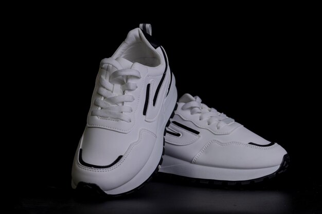 White sports sneakers on a black background