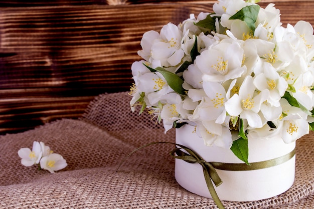 White spring flowers in the box on the rustic wooden background