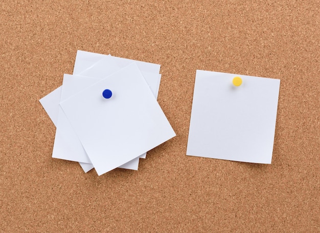 White square blank pieces of paper pinned on a cork board, copy space