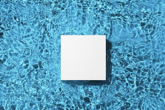 Photo white square podium on the blue water surface background flat lay copy space