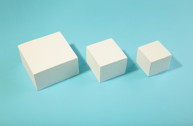 White square podiums on blue background. Trend fashion showcase for cosmetic products, goods, shoes, bags, watches.