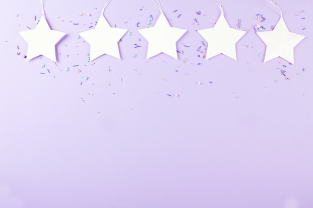 White star, purple background, party decor. Top view. Copy space.