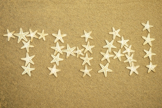 Белая морская звезда надпись слова Таиланд на песке. Таиланд на песке от морских звезд. концепция отпуска и путешествий.