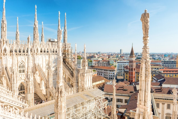 Statua bianca in cima al duomo e vista sulla città di milano