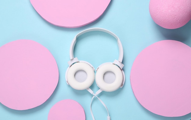 Cuffie stereo bianche su sfondo blu con cerchi rosa layout musicale moderno e minimalista