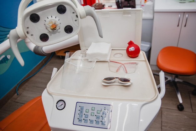 White stomatological unit for children in a children39s dental clinic On the stand protective glasses napkins and a toy