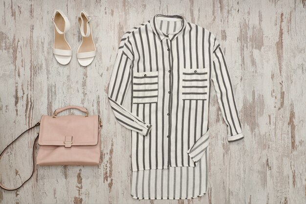 White striped shirt, white shoes and a beige bag.