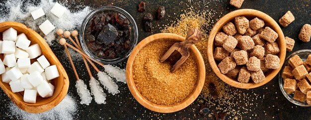 white sugar, cane sugar cubes, caramel in bamboo bowl on dark brown table