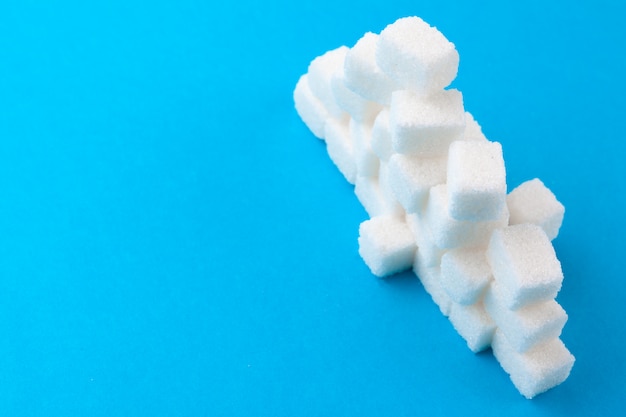 White sugar cubes on a bright blue 