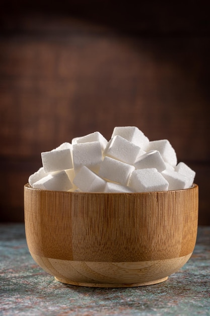 White sugar cubes in wooden bowl