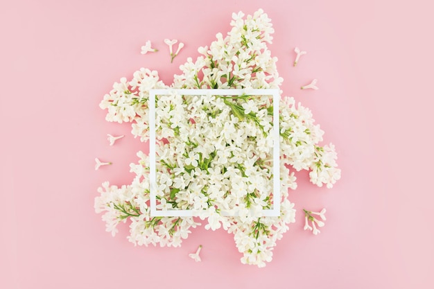 White summer lilac branches frameflowers on a pink background Floristry