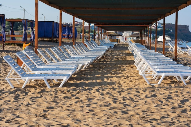 White sun loungers on the beach in summer no people