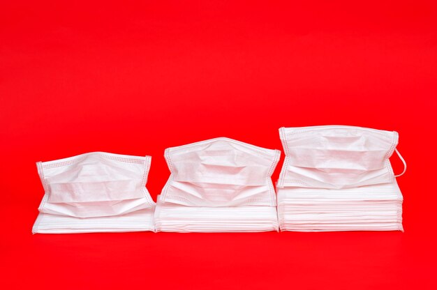 White surgical masks on red. Concept statistical graph showing increased consumption of masks