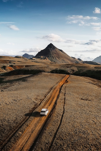 White SUV driving on a dusty sand road