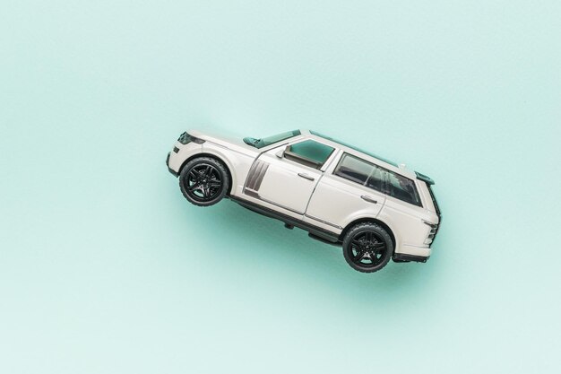 A white SUV on a light blue background The concept of auto mania Flat lay