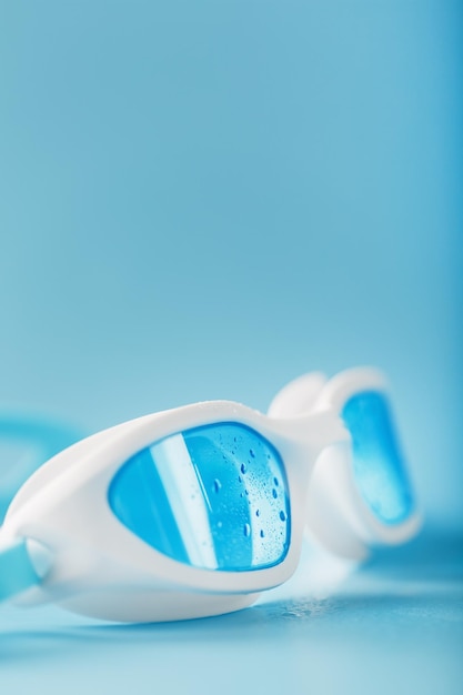 White swimming goggles on a blue background