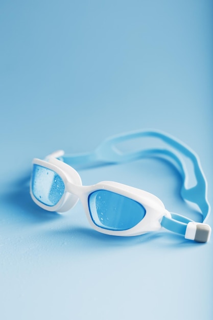 White swimming goggles on a blue background