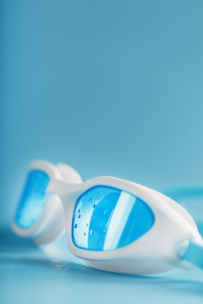 White swimming goggles on a blue background