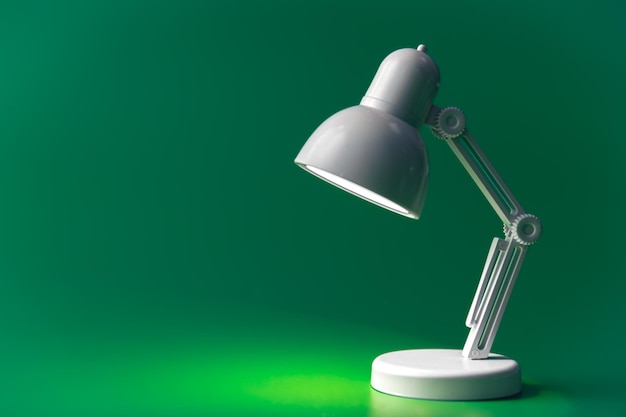 White table lamp on a green background copy space