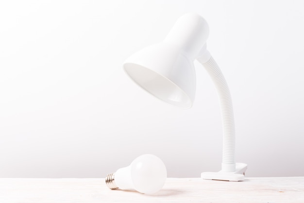 Белая настольная лампа на деревянном столе