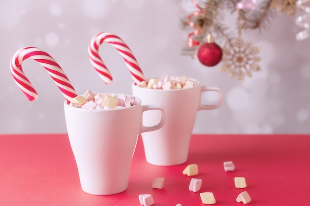 On a white table marshmallows in a cup with latte