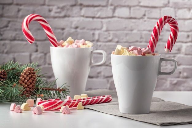 On a white table marshmallows in a cup with latte