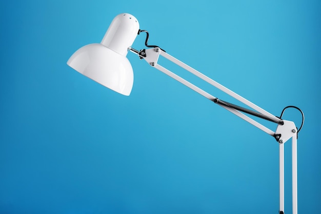 White table office lamp on blue background with space for text and idea concept